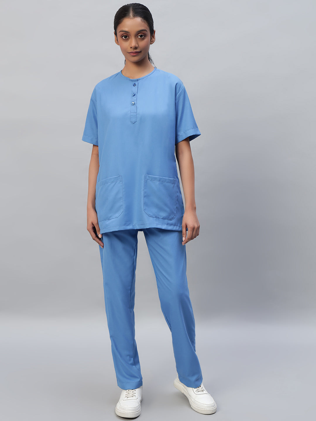 A female wearing a Sky Blue Medical Scrub Suit with a round neck and half sleeves.